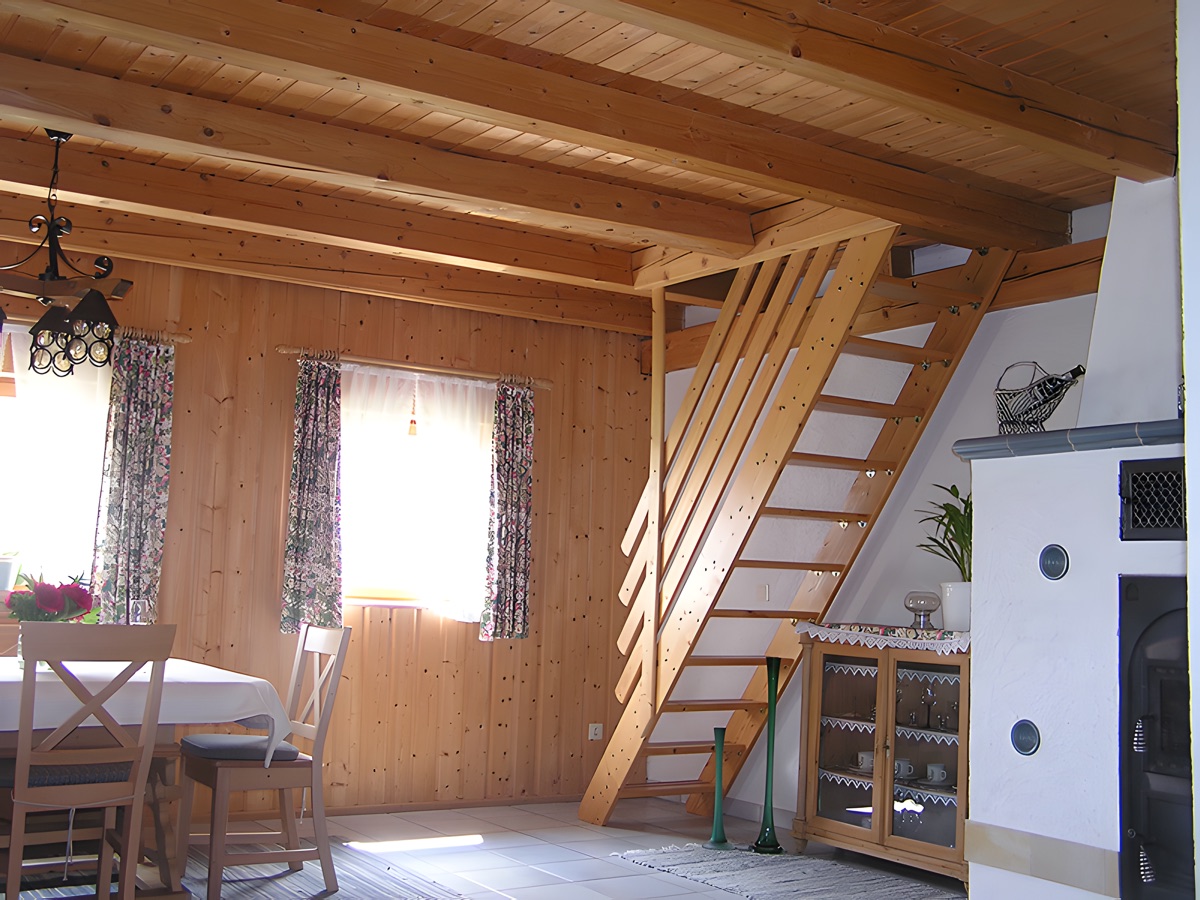 Wohnraum mit Esstisch und Holztreppe