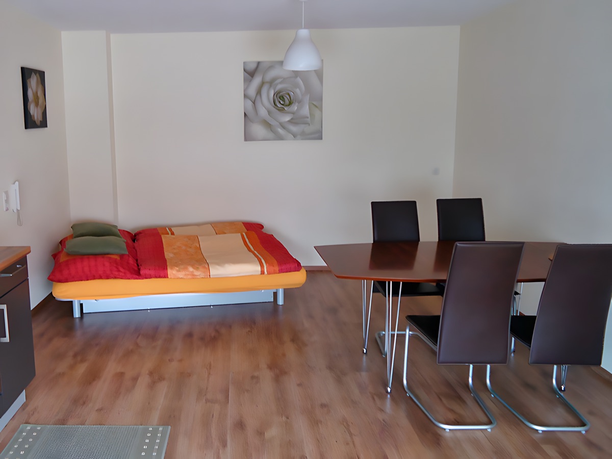 Wohnraum mit Esstisch und zusätzlichem Bett